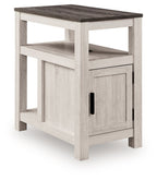 Chair side end table with open shelf and one-door cabinet, whitewashed light wood, black pulls.