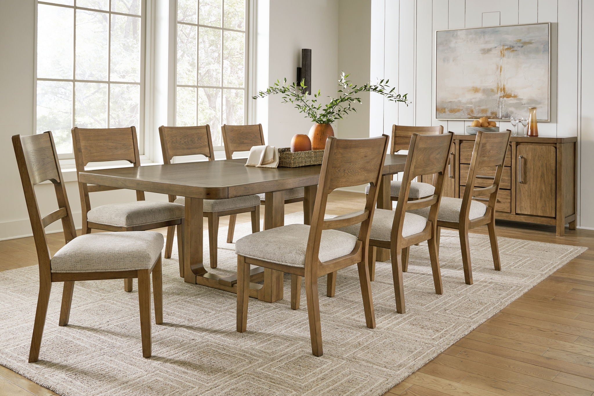 Light brown dining table with multiple upholstered chairs