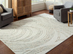 Deenbury rug in off-white with beige and gray swirl design in open seating area