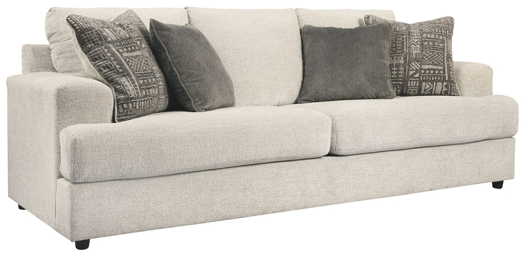 Stone sleeper sofa with light upholstery and dark patterned throw pillows