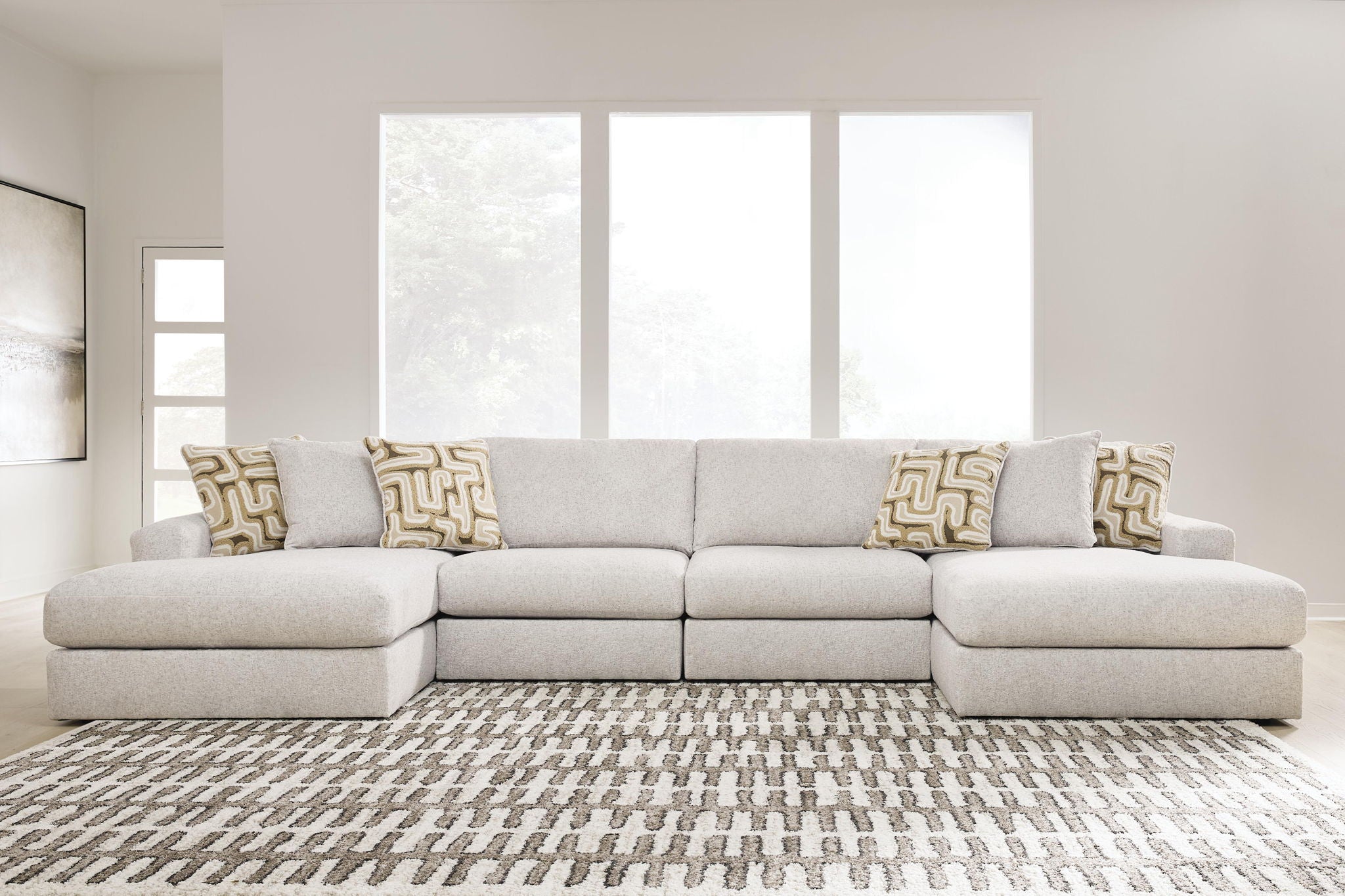 Light beige sectional sofa with three back cushions and patterned throw pillows.