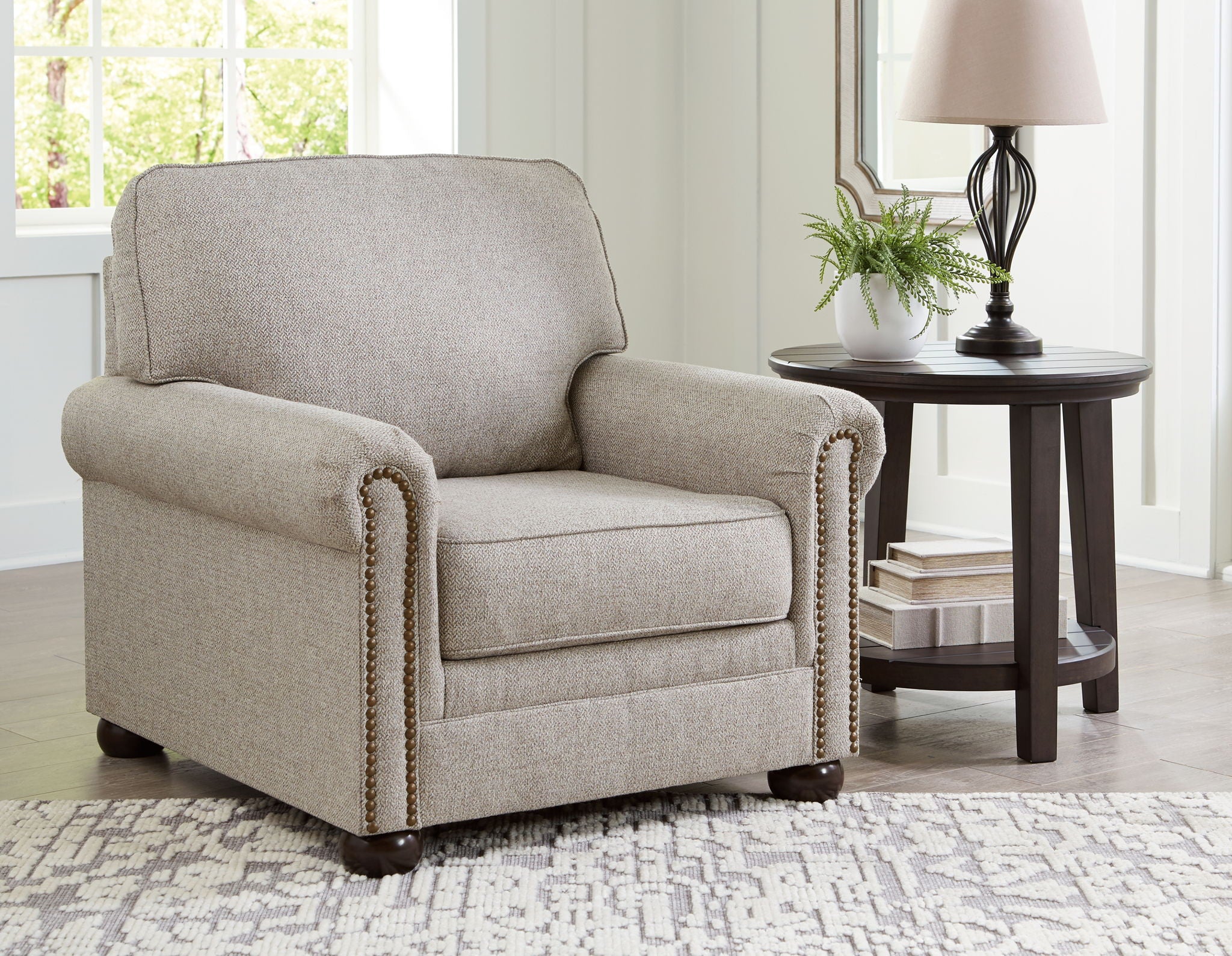 Light gray upholstered accent chair with patterned trim along the arms.