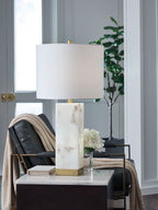 Table lamp with white drum shade, alabaster-style base, and gold accent mount