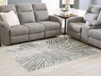 Gray and ivory washable area rug with radial sunburst motif in a living room setting