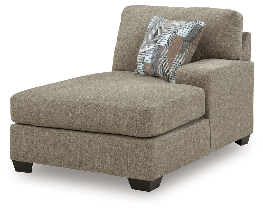 Beige fabric corner chaise with ottoman-style seat and striped throw pillow