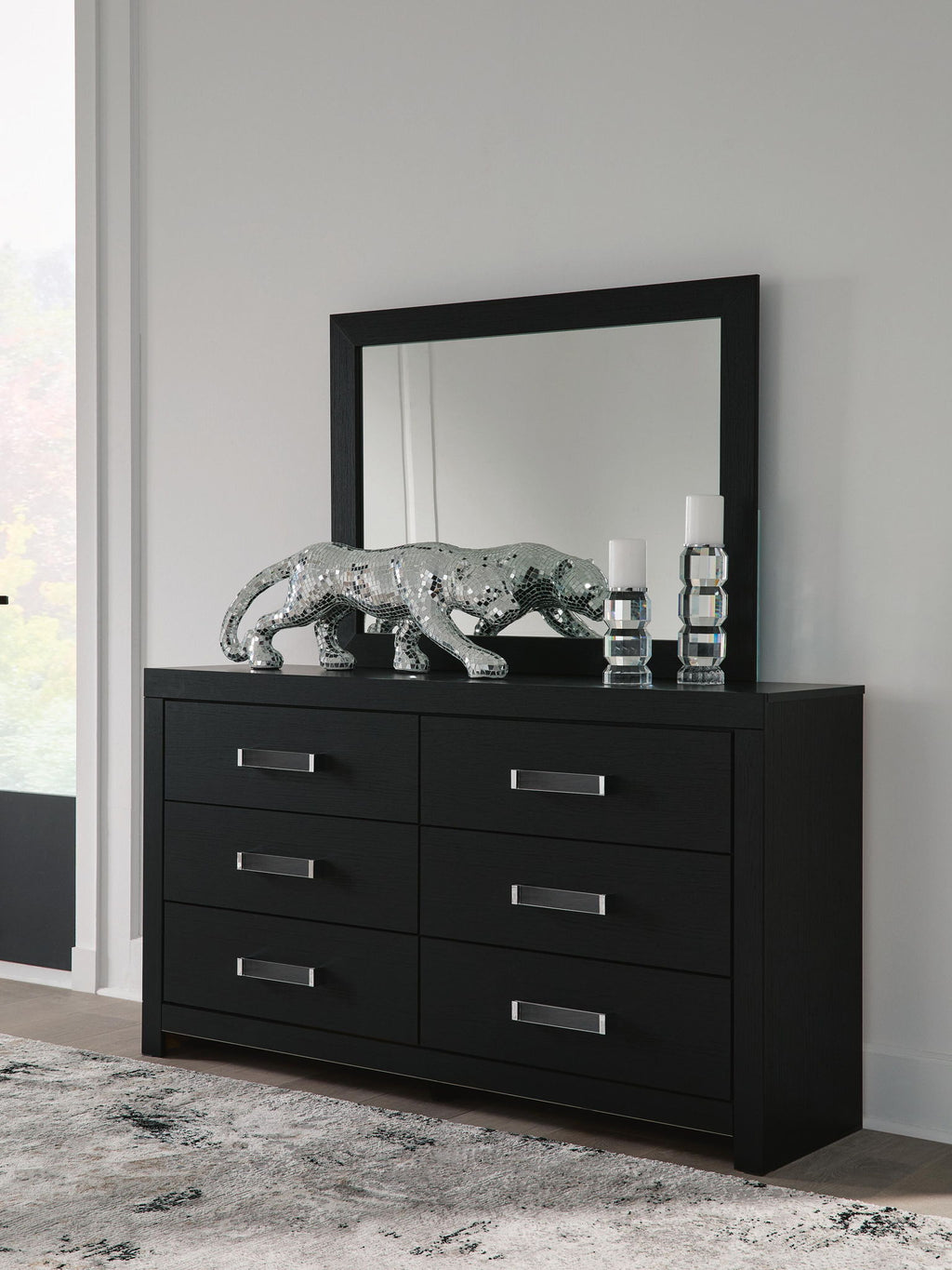 Black six-drawer dresser with six silver bar handles and front view.
