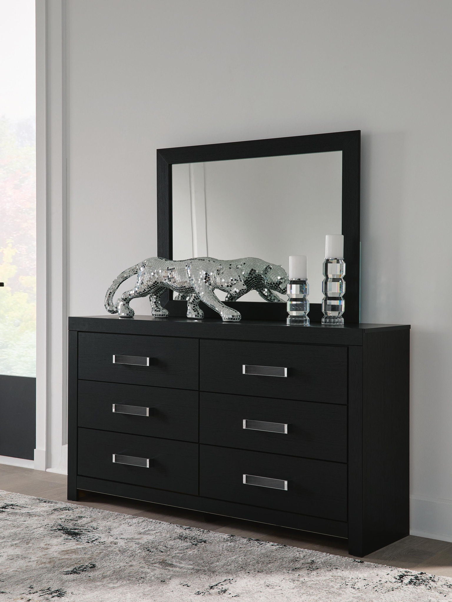 Black six-drawer dresser with six silver bar handles and front view.