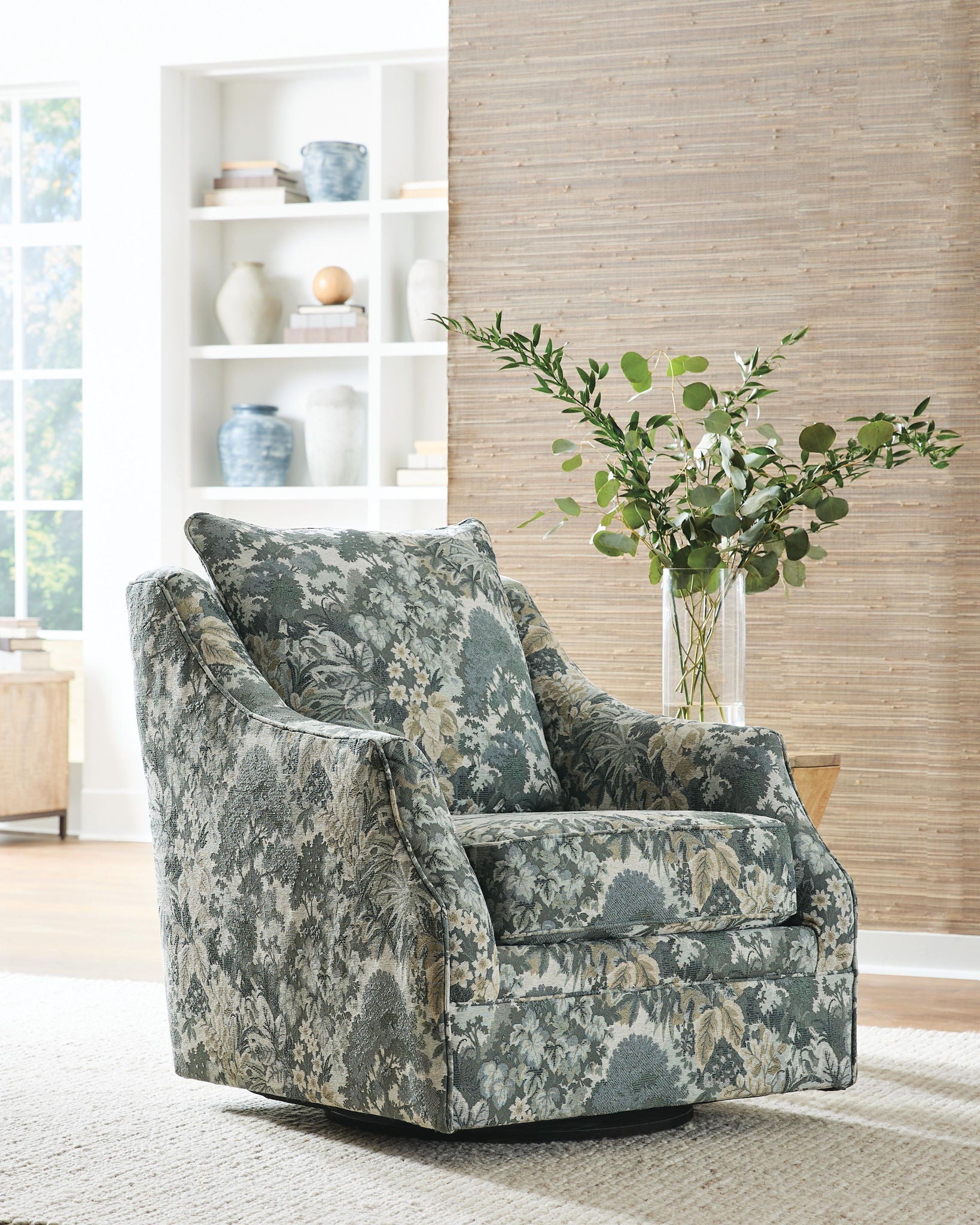 Green floral upholstered swivel accent chair with high back and thick seat cushion.