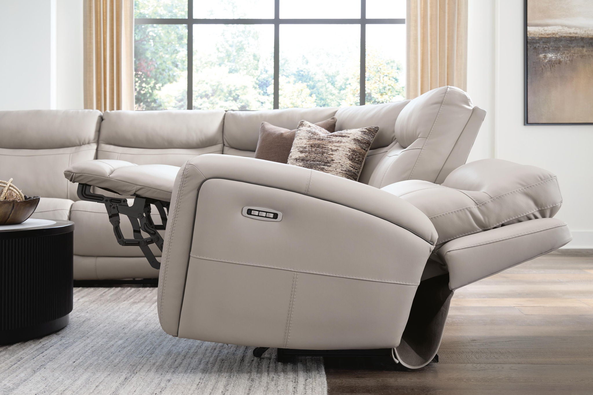 Gray power recliner section of a sectional sofa with padded armrest and seat