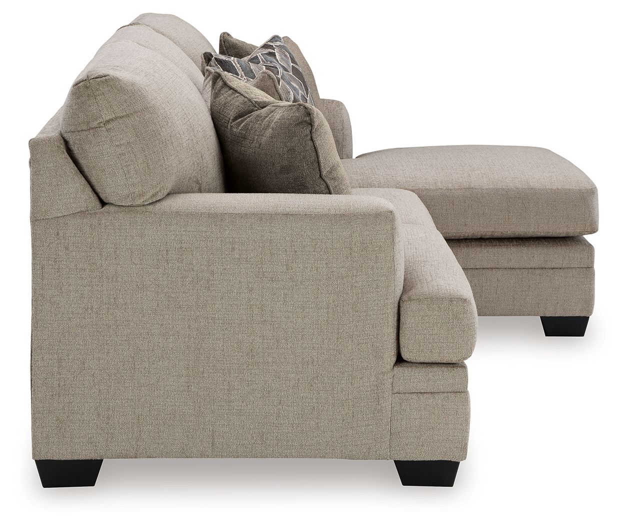 Light brown fabric sofa with chaise-style back, rolled arms, and two accent pillows