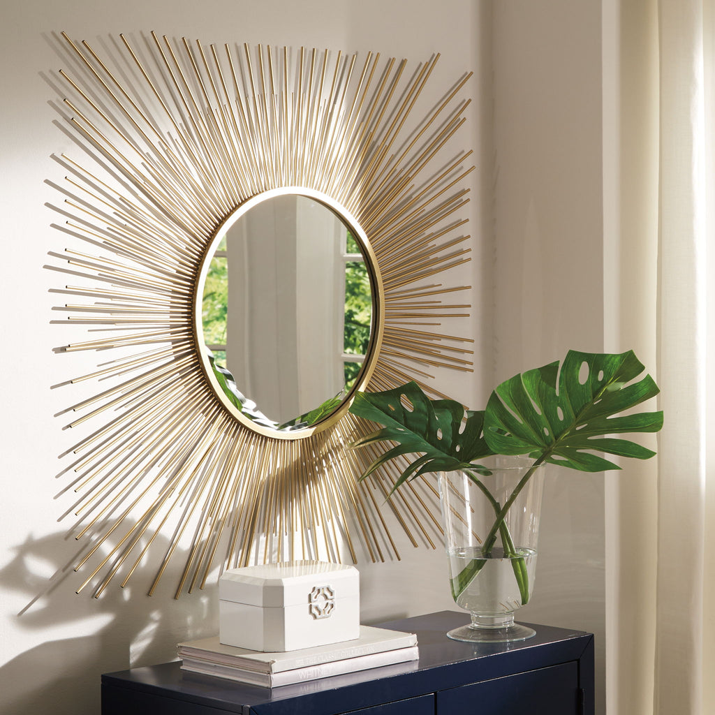 Gold round accent mirror with radiating rods and a reflective glass face