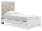 White panel bed with light gray upholstered headboard and side view of footboard drawers.