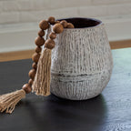 Ceramic vase with tassel and wooden bead garland, dark interior rim, speckled light gray