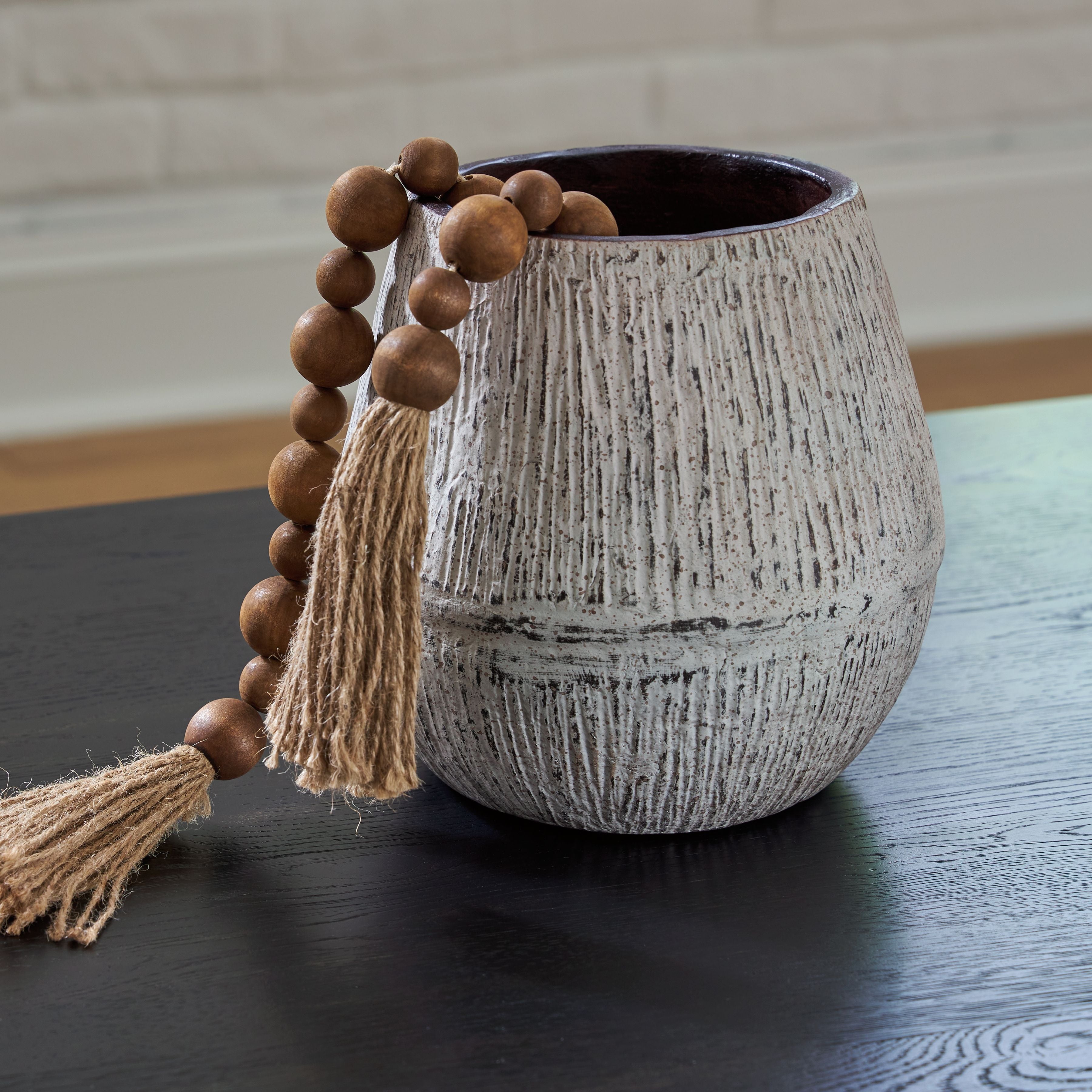 Ceramic vase with tassel and wooden bead garland, dark interior rim, speckled light gray