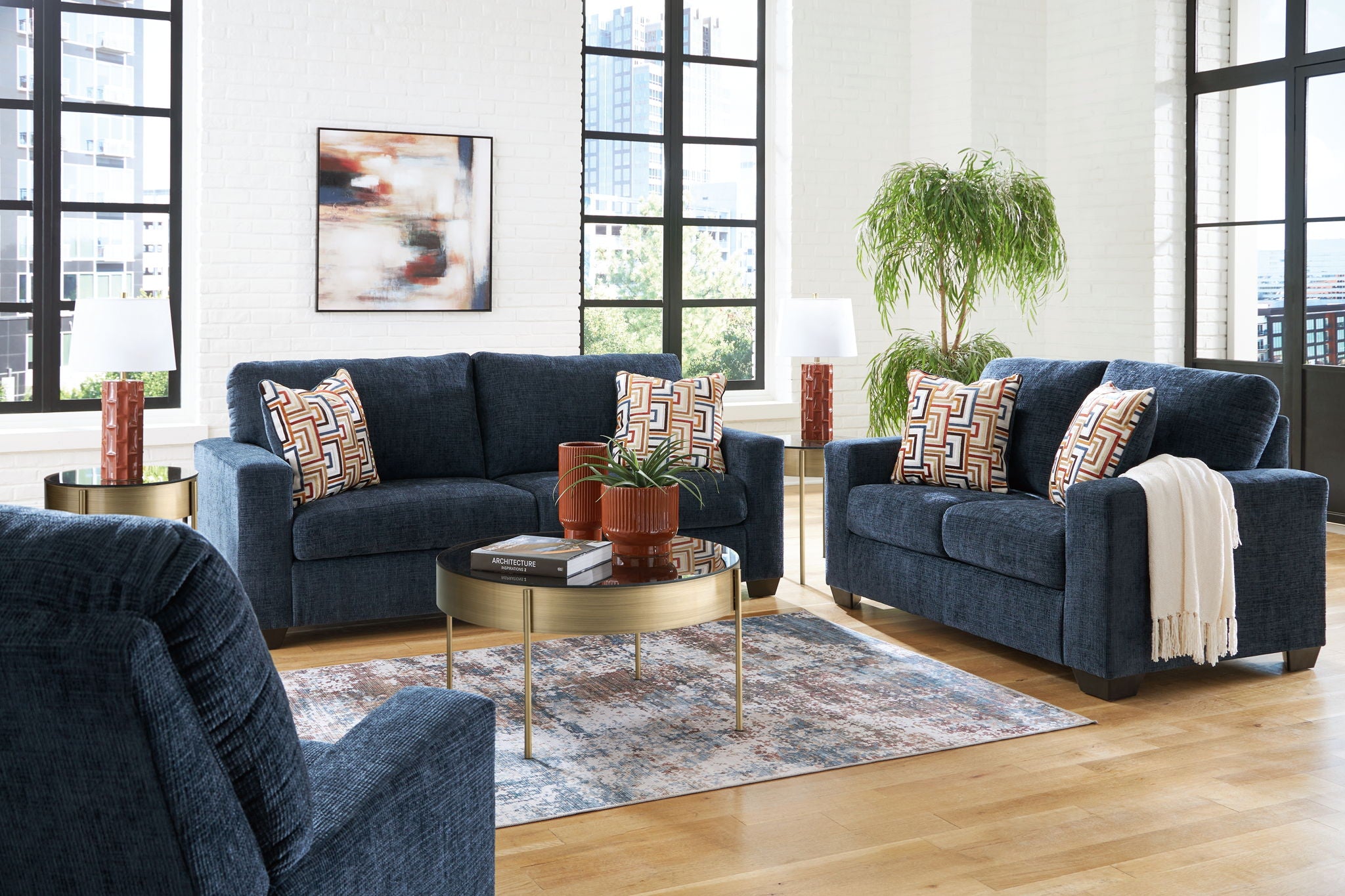 Navy blue sofa set with patterned pillows and white throw blanket