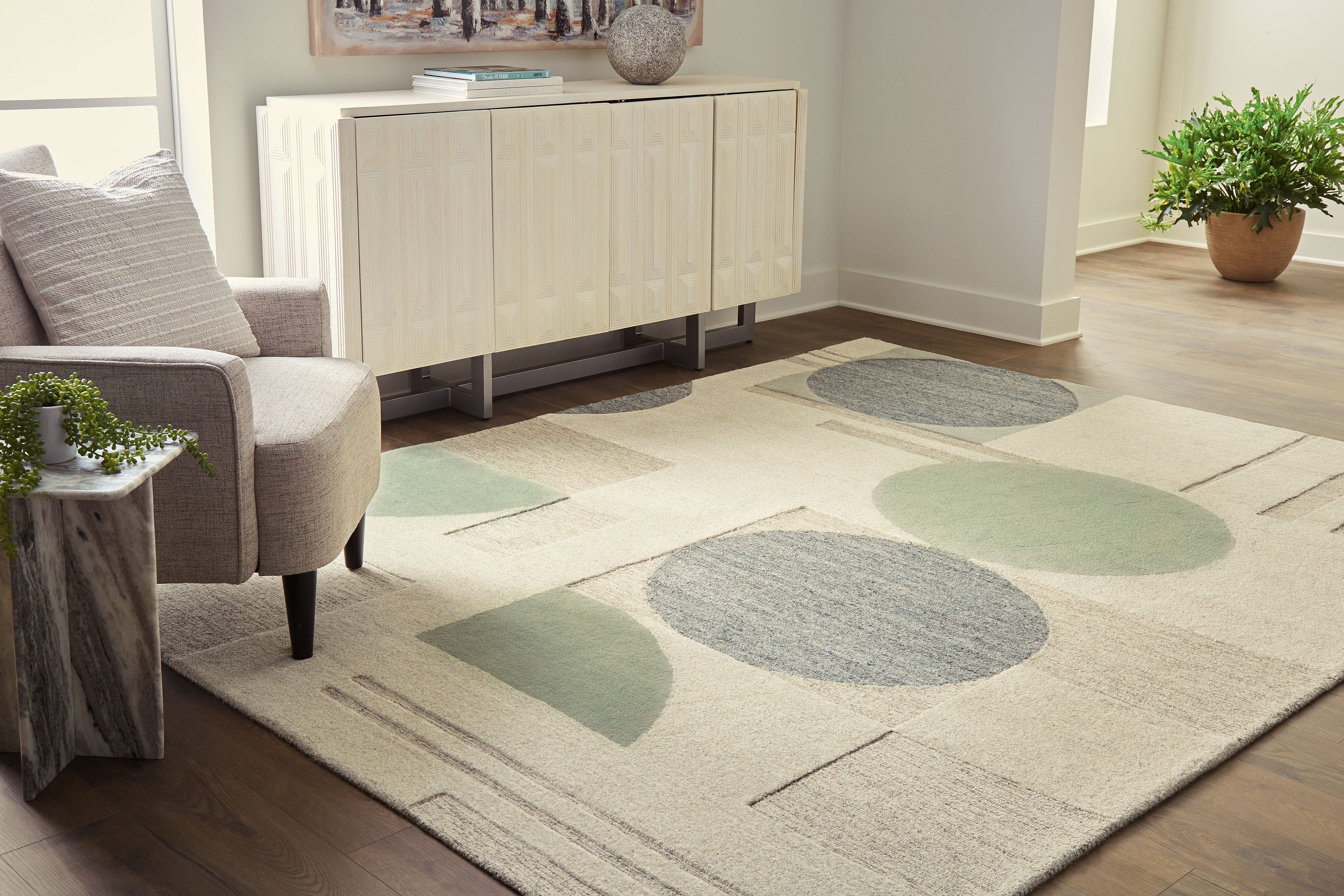 Ivory area rug with large abstract ovals and geometric lines in gray and sage
