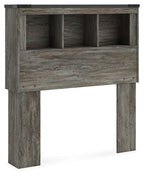 Gray bookcase headboard with open cubbies and a horizontal storage panel