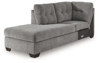 Gray corner chaise sofa with tufted back, upholstered arms, and dark wooden legs