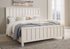 White panel bed with tall slat headboard, mattress, and pillows in a bedroom setting