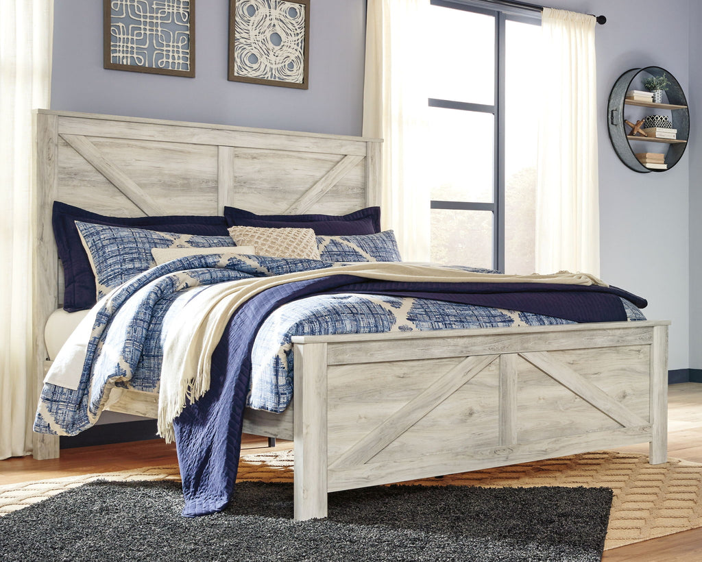Beige crossbuck panel bed with blue-and-white bedding and cream throw blanket