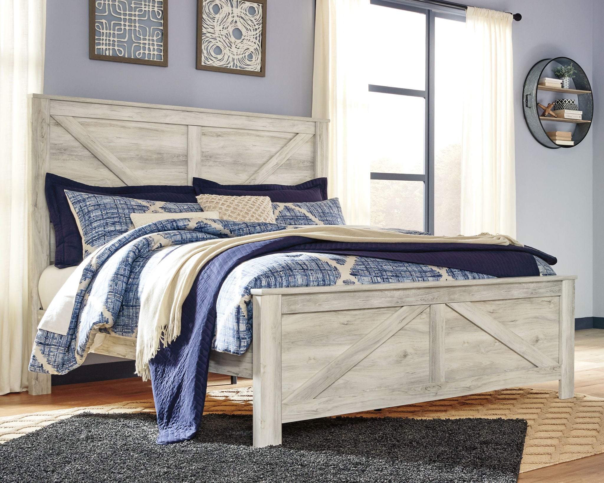 Beige crossbuck panel bed with blue-and-white bedding and cream throw blanket