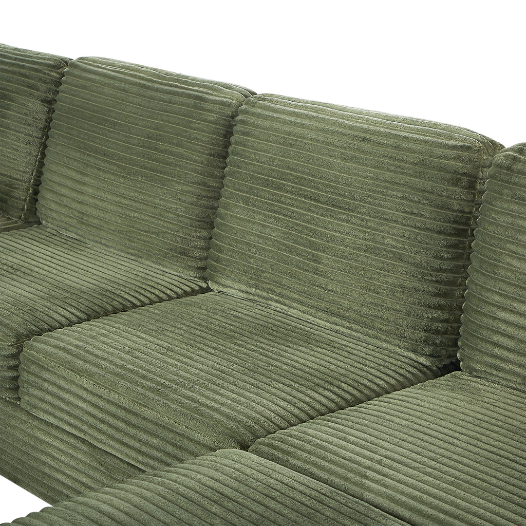Green corduroy sectional sofa cushion close-up with stitched seams