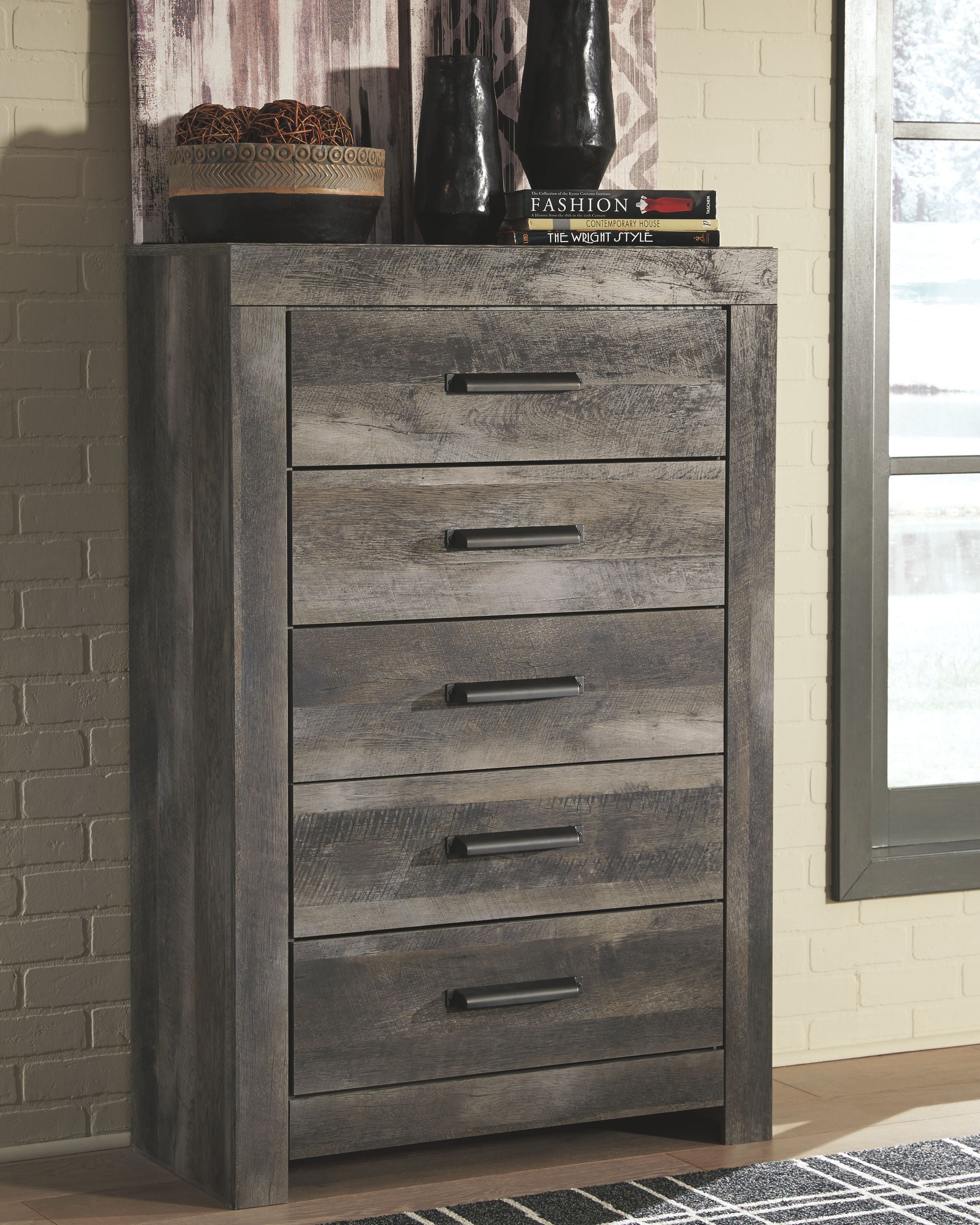 Gray five-drawer chest in angled view with five drawers and dark metal pulls.