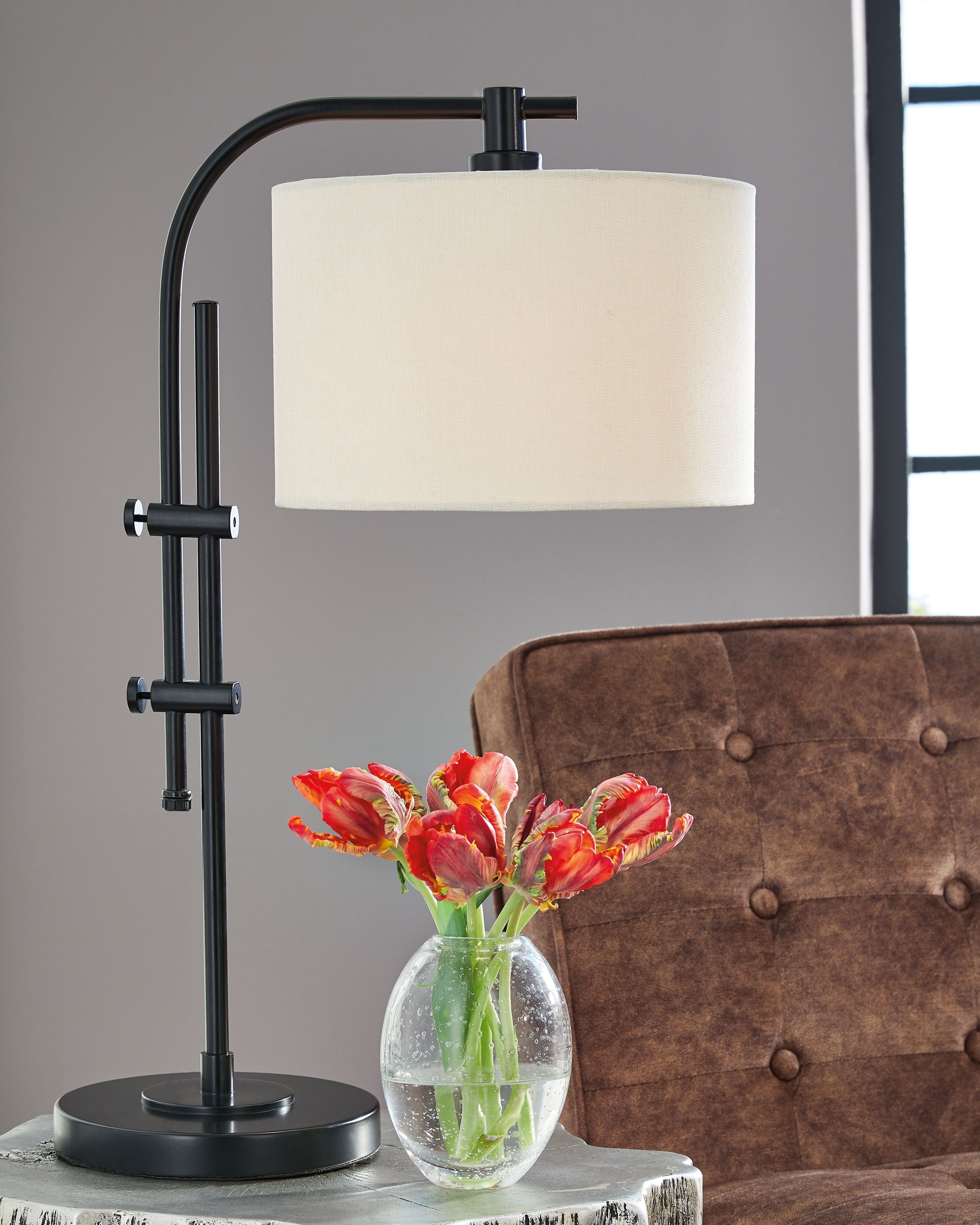 Black metal floor lamp with cream drum shade and curved arm