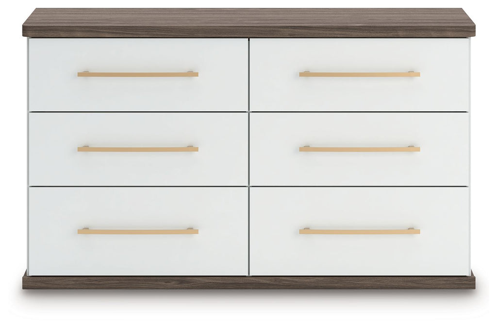 Six-drawer dresser with white finish, warm wood top and sides, and gold bar pulls.