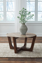Round warm brown wooden cocktail table with curved supports and round top
