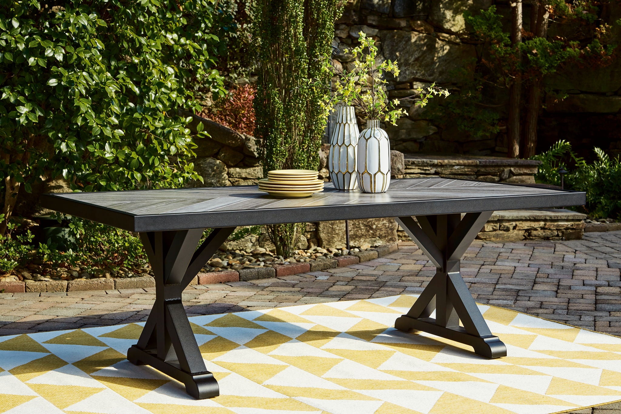 Rectangular dining table with black legs and light gray slatted tabletop
