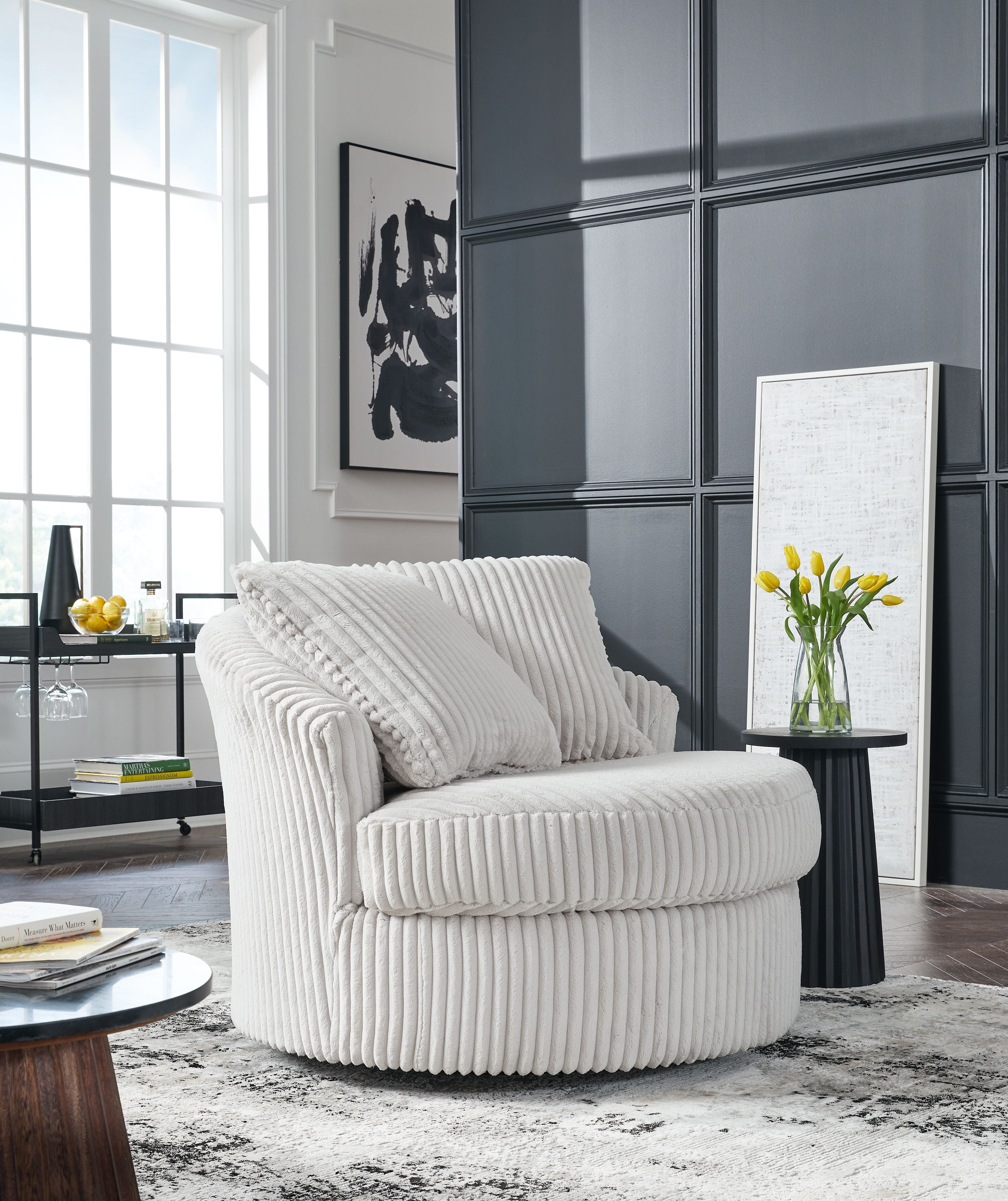 Swivel chair with ribbed light upholstery, two back cushions, and rounded armrests