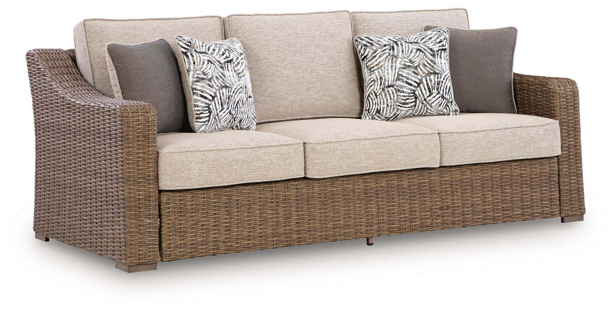 Beige fabric sofa with wicker base and two patterned throw cushions