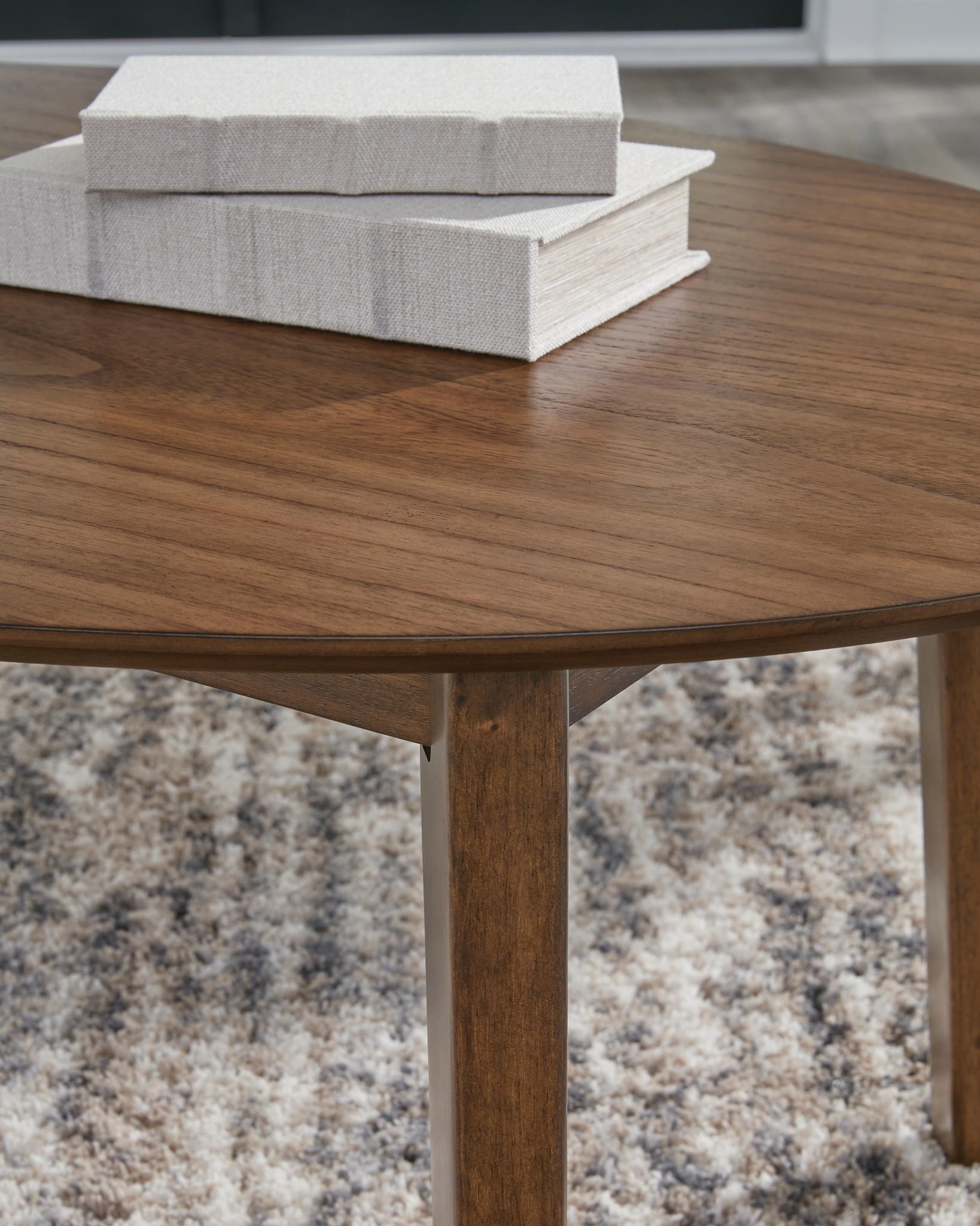 Brown round wooden coffee table top with visible grain and solid tapered legs