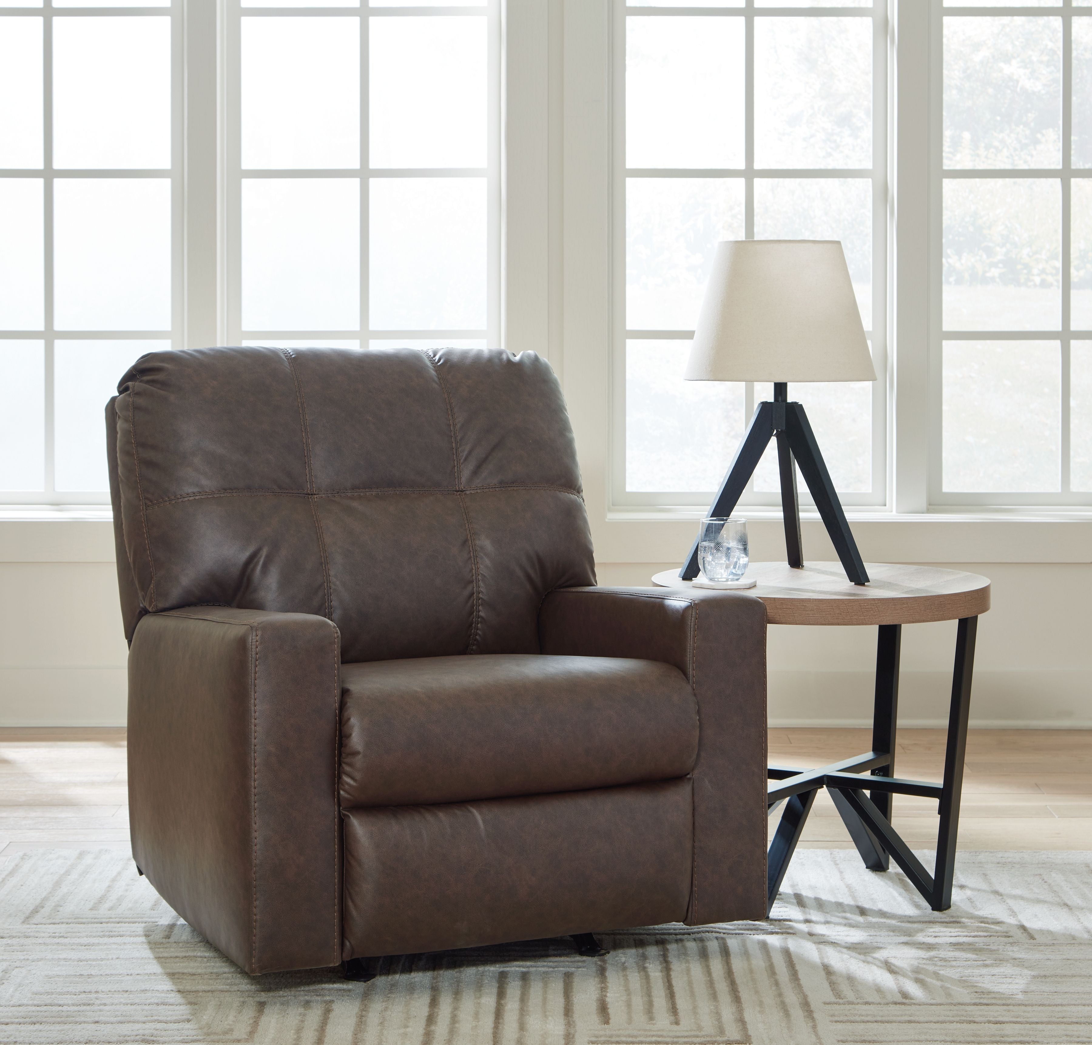 Brown rocker recliner with padded arms, tufted back, and smooth cushioned seat