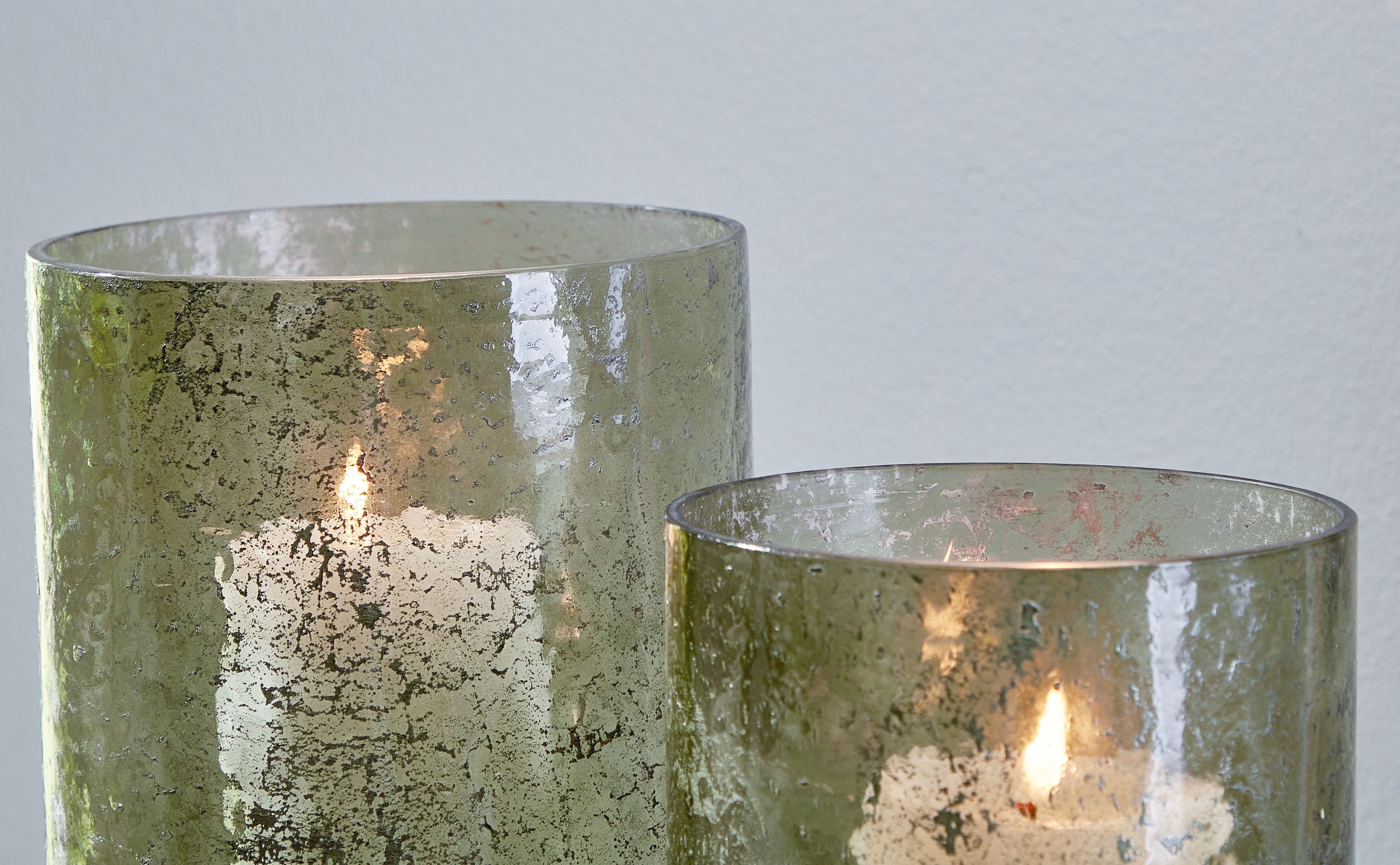 Clarkton green candle holder set (2): lit candles in textured glass cylinders with open rims