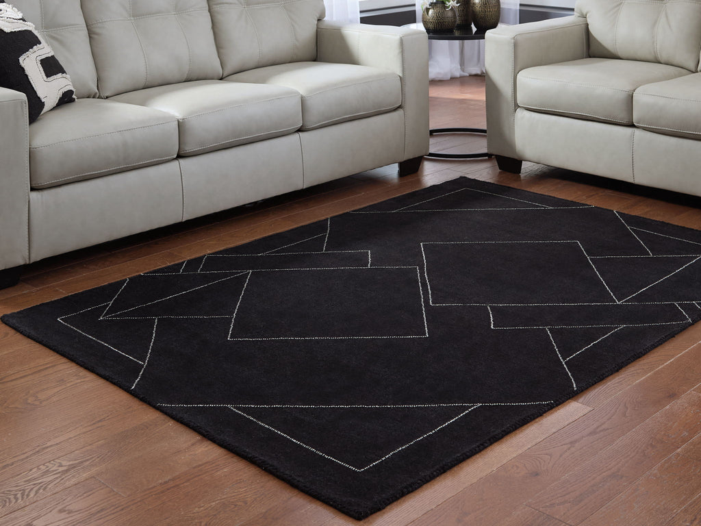 Black geometric area rug with white outlined rectangles and diamonds on hardwood