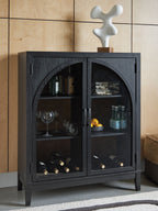Black bar cabinet with arched glass doors showing bottles, stemware, and wine storage