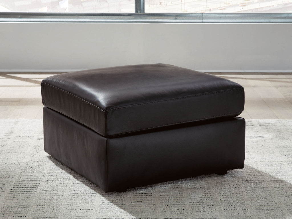 Black rectangular ottoman with cushioned seat and short legs