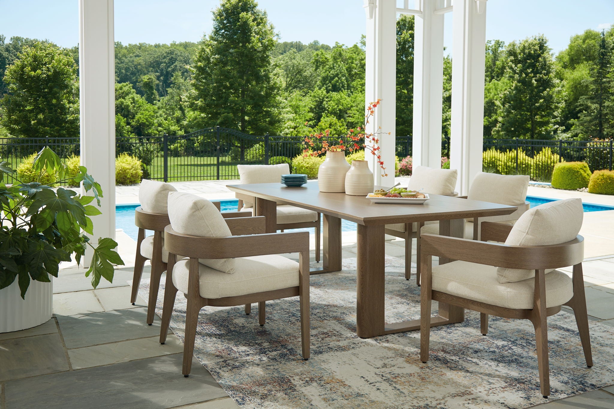 Outdoor dining set with dark brown table and beige-cushioned chairs outdoors