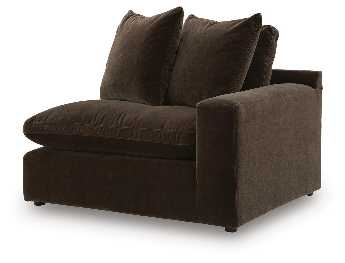 Dark brown corner armchair with tufted seat cushion, rounded arms, and three pillows