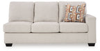 Light beige fabric sofa with three seat cushions, three back cushions, and geometric throw