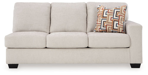 Light beige fabric sofa with three seat cushions, three back cushions, and geometric throw