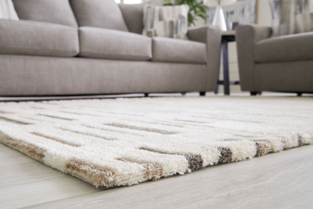 Pearl silver rug with textured short pile and dark gray stripe motif at edge