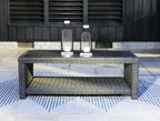 Gray rectangular cocktail table with woven frame and gray cushion shelf