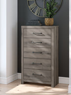 Five-drawer chest in gray wood with metal bar pulls, full front view.