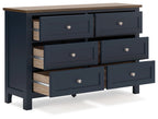 Blue dresser with exposed wood drawer interiors and round silver knobs