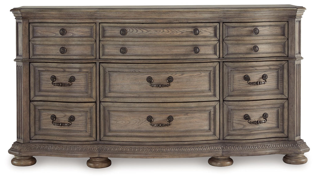 Light brown wood dresser front with rows of drawers and black handle pulls