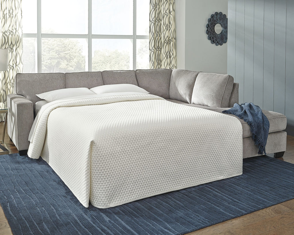 Light gray sleeper sectional with chaise, bed unfolded and mattress visible.