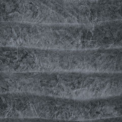 Grey sculpted table lamp base with ridged texture under fabric shade